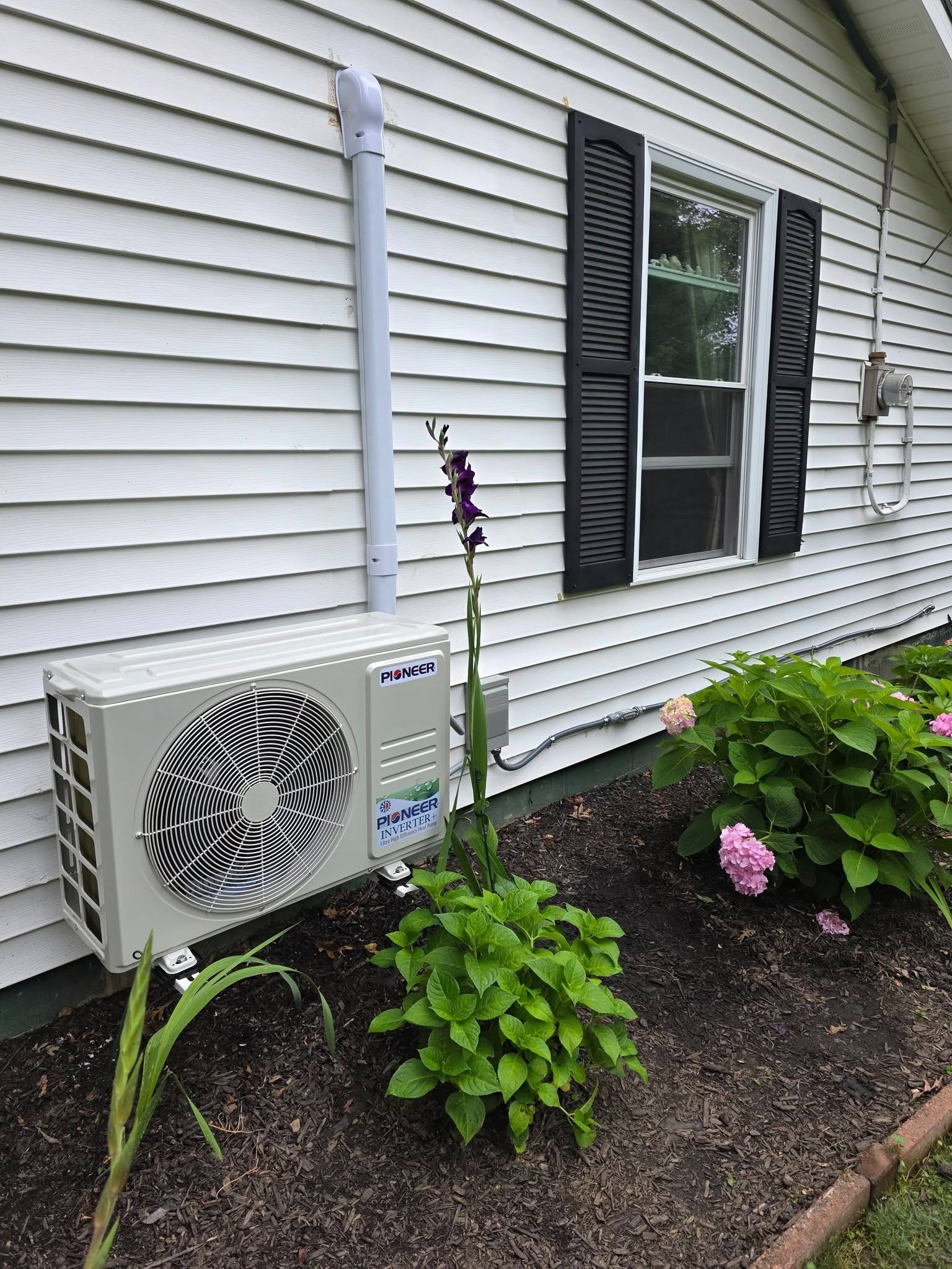 Ductless mini-split heat pump installed beside a home